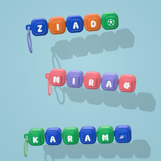 Three Squigli name clicker keychains spelling Ziad, Mira and Karam, each with its own symbol