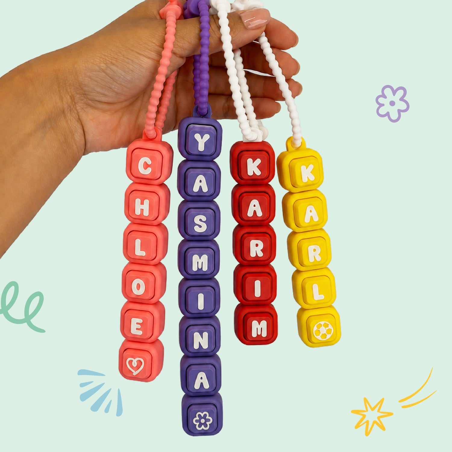 A name strand of colorful letter clickers spelling Layla with a heart
